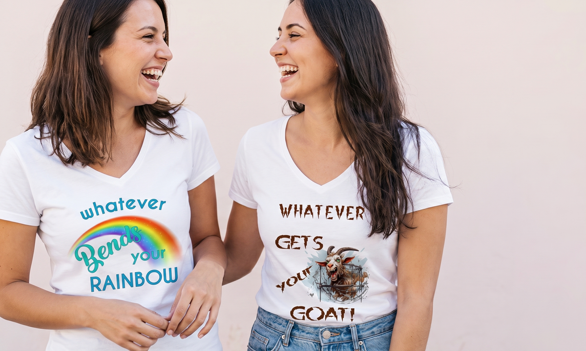 Two women laughing together wearing the Whatever Bends your Rainbow and Whatever Gets your Goat tees